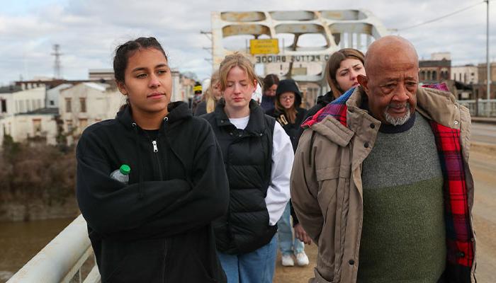 Civil rights activist Charles Mauldin, left, and 体育菠菜大平台 sophomore Jamie Vaughn lead a group of political science students across Edmund Pettus Bridge in Selma, Alabama